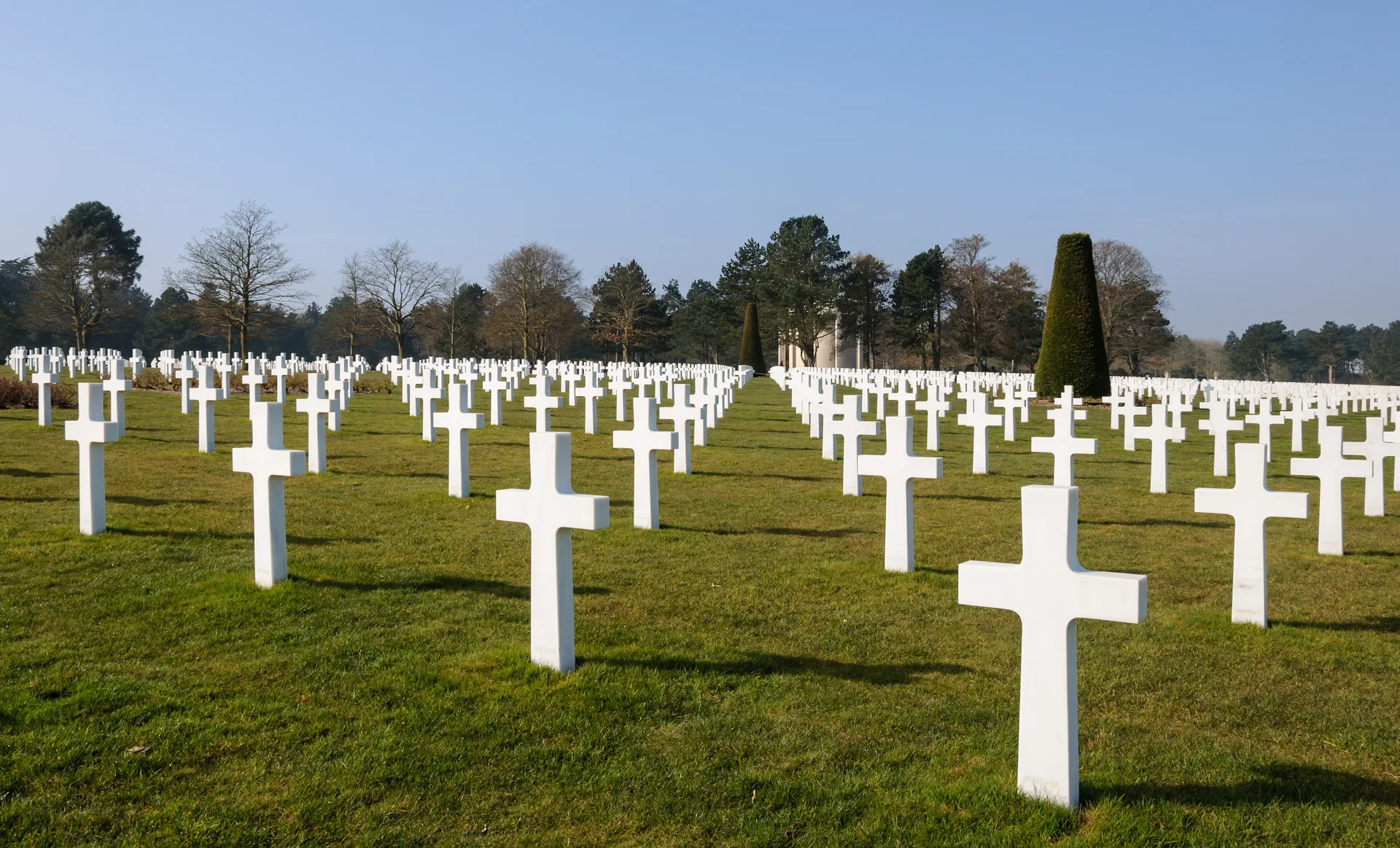 Řady bílých mramorových náhrobků na Normandském americkém hřbitově nad pláží Omaha Beach, Colleville-sur-Mer